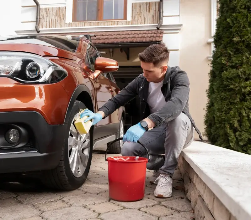 Lavage auto à domicile Vézins-de-Lévézou : professionnel intervenant sur un véhicule